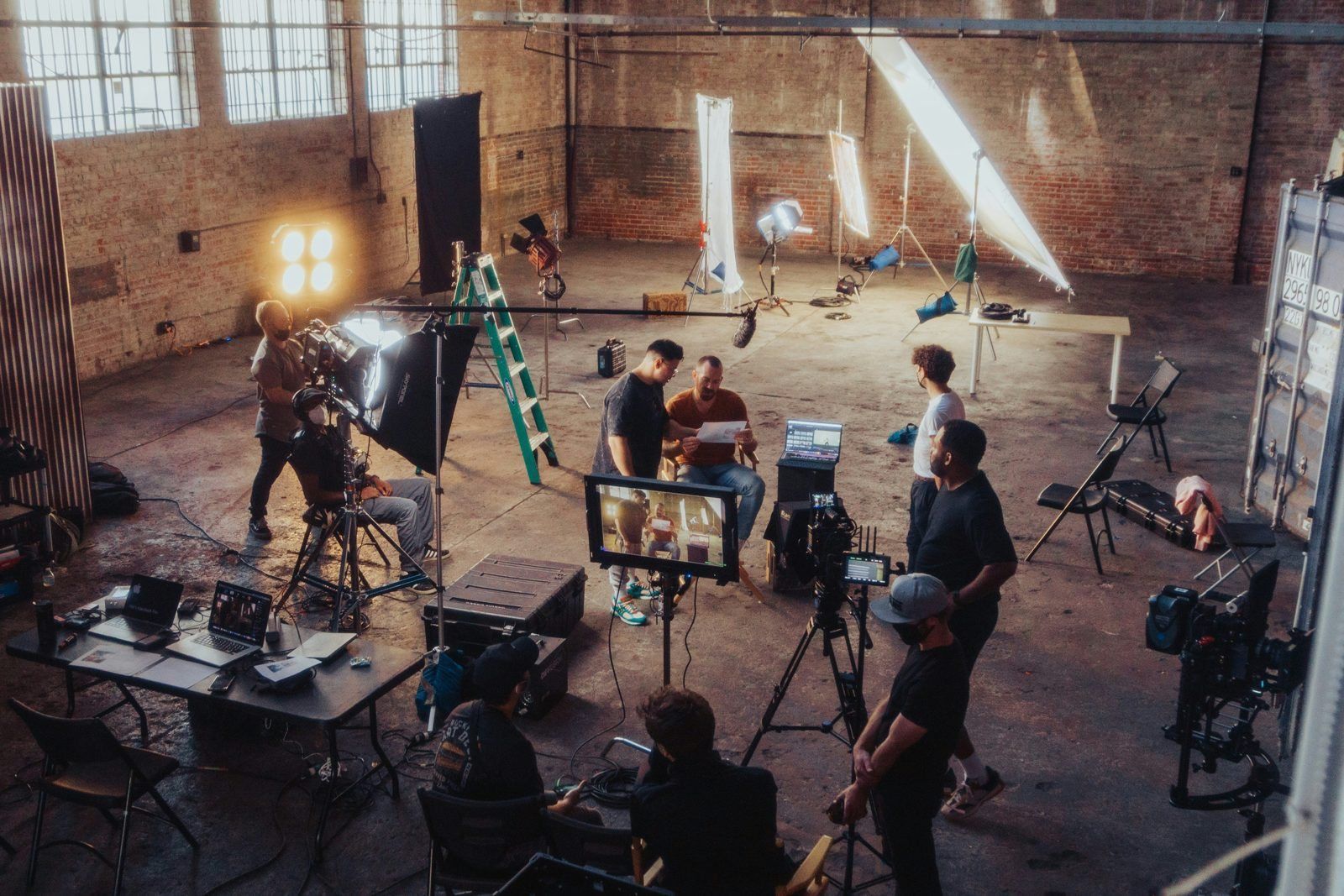 A creative production team reviewing a storyboard on set, illustrative of design and production running as one team
